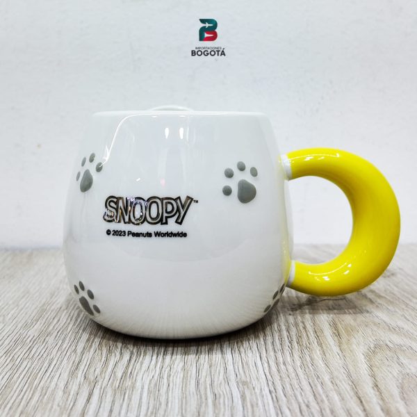Parte trasera del Mug Snoopy Amarillo con huellitas grises y logo SNOOPY ©2023