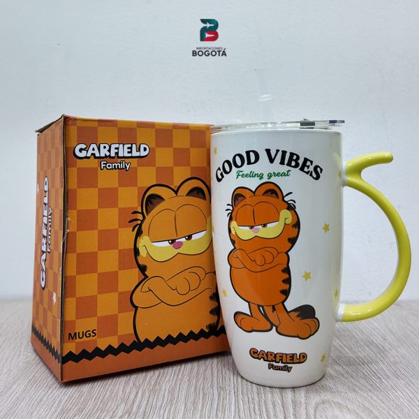 Mug Garfield blanco con asa amarilla, tapa y pitillo; Garfield de pie con texto “GOOD VIBES – Feeling great”.