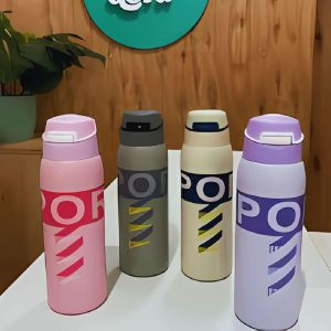 Termo sport 350 ml de acero inoxidable con tapa de botón y boquilla abatible, colores pastel y oscuros, sobre mesa de interior.